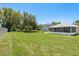 Large, green backyard with ample space, a screened-in lanai, and mature trees at 6351 Desert Peace Ave, Land O Lakes, FL 34639