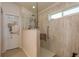 Accessible shower stall featuring glass door, seat, grab bar and window for natural light at 6351 Desert Peace Ave, Land O Lakes, FL 34639