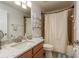 Neutral bathroom showcasing a shower with curtain, toilet, and a vanity sink with white countertop at 6351 Desert Peace Ave, Land O Lakes, FL 34639