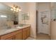 Bright bathroom featuring double sinks, large mirror and accessible glass door shower at 6351 Desert Peace Ave, Land O Lakes, FL 34639