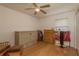 Bright bedroom showcasing a ceiling fan, wood laminate floors, murphy bed and neutral paint at 6351 Desert Peace Ave, Land O Lakes, FL 34639