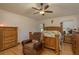 Comfortable bedroom with a ceiling fan, wood floors, and matching furniture at 6351 Desert Peace Ave, Land O Lakes, FL 34639