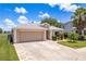 This single story home has a well manicured lawn, a two car garage, and paver details on the driveway at 6351 Desert Peace Ave, Land O Lakes, FL 34639