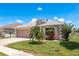 Well maintained lawn with a palm tree and manicured landscaping in front of the beige single story home at 6351 Desert Peace Ave, Land O Lakes, FL 34639
