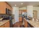 Modern kitchen with granite countertops, stainless steel appliances, and wood floors at 6351 Desert Peace Ave, Land O Lakes, FL 34639