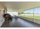 Enclosed patio featuring tile floors, white framed screening and overlooking the fenced backyard at 6351 Desert Peace Ave, Land O Lakes, FL 34639