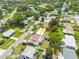 Aerial view of the property featuring mature trees, the community, and a nearby pond at 6730 10Th Avenue S Ter, St Petersburg, FL 33707