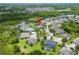 Aerial view highlighting the home's position near a lush green forest and a pond at 8332 Swiss Chard Cir, Land O Lakes, FL 34637