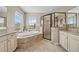 Bathroom with a luxurious bathtub, glass shower, tile floors and bright window at 8332 Swiss Chard Cir, Land O Lakes, FL 34637