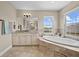 Bathroom featuring a large tub, granite countertop vanity, and a large window at 8332 Swiss Chard Cir, Land O Lakes, FL 34637