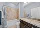 Cozy bathroom with tiled shower over tub, granite counters, and ample lighting at 8332 Swiss Chard Cir, Land O Lakes, FL 34637