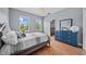 Light-filled bedroom with hardwood floors and a large blue dresser at 8332 Swiss Chard Cir, Land O Lakes, FL 34637