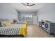 Bright bedroom with hardwood floors, ceiling fan, and two twin beds with yellow accents at 8332 Swiss Chard Cir, Land O Lakes, FL 34637