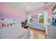 Charming bedroom with pink and blue walls and natural lighting at 8332 Swiss Chard Cir, Land O Lakes, FL 34637