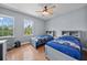 Bright bedroom featuring two twin beds, natural light, and ceiling fan at 8332 Swiss Chard Cir, Land O Lakes, FL 34637