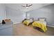 Bright bedroom featuring two twin beds and a ceiling fan for added comfort at 8332 Swiss Chard Cir, Land O Lakes, FL 34637
