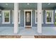 Charming front door entrance framed by classic columns and stylish windows, enhancing curb appeal at 8332 Swiss Chard Cir, Land O Lakes, FL 34637