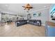 Open-concept living room boasts tile floors, a ceiling fan, and access to kitchen and dining areas at 8332 Swiss Chard Cir, Land O Lakes, FL 34637