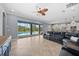 Bright living room with tile floors, a ceiling fan, and sliding glass doors to the pool area at 8332 Swiss Chard Cir, Land O Lakes, FL 34637