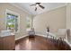 Bright home office features hardwood floors, two windows, ceiling fan, and stylish desk with chairs at 8332 Swiss Chard Cir, Land O Lakes, FL 34637