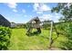 Wooden playground with swings and slide set in a spacious backyard at 8332 Swiss Chard Cir, Land O Lakes, FL 34637