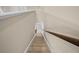 View looking down the carpeted staircase with wooden handrail and neutral walls at 8332 Swiss Chard Cir, Land O Lakes, FL 34637