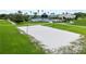 Sandy community sand volleyball court surrounded by green grass and community facilities in the background at 8332 Swiss Chard Cir, Land O Lakes, FL 34637