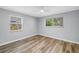 Bright bedroom with wood-look floors, ceiling fan, and sunlit windows at 914 Sandpiper Way S, St Petersburg, FL 33707