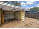 Attached carport featuring a white garage door, access door, and built-in shelving at 914 Sandpiper Way S, St Petersburg, FL 33707