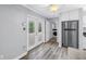 Interior shot featuring wood-look floors, stainless steel refrigerator, and french doors with backyard access at 914 Sandpiper Way S, St Petersburg, FL 33707