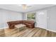 Cozy living room featuring wood-look floors, a brown leather sofa, and a window view at 914 Sandpiper Way S, St Petersburg, FL 33707