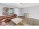Cozy living room features a brown leather sofa and a window with a front yard view at 914 Sandpiper Way S, St Petersburg, FL 33707