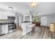 Open living space featuring stainless steel appliances, tile backsplash, and wood-look flooring at 914 Sandpiper Way S, St Petersburg, FL 33707