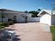 Private backyard with brick-paved driveway, bench, white fencing and mature landscaping at 9218 40Th N Way, Pinellas Park, FL 33782