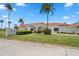 Charming building with red tile roof, manicured lawn, and palm trees under a clear blue sky at 9218 40Th N Way, Pinellas Park, FL 33782