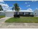 Charming single-story home featuring a well-maintained lawn, white exterior, and blue shutters at 9218 40Th N Way, Pinellas Park, FL 33782