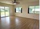 Living room featuring wood floors, a sliding door to the back yard, and large windows at 9218 40Th N Way, Pinellas Park, FL 33782