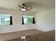 Bright living room featuring wood floors, large windows and a modern ceiling fan at 9218 40Th N Way, Pinellas Park, FL 33782