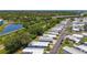 Scenic aerial view of a well-maintained mobile home community alongside a pond, railroad tracks, and lush green spaces at 9790 66Th N St # 353, Pinellas Park, FL 33782