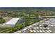 Expansive aerial view showcasing the mobile home community, pond, commercial building, golf course, and lush greenery at 9790 66Th N St # 353, Pinellas Park, FL 33782