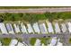 Aerial view of a mobile home community with orderly streets, lush greenery, and a nearby railway at 9790 66Th N St # 353, Pinellas Park, FL 33782