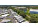 Wide aerial shot capturing the extensive mobile home community, with a pond and commercial building in the backdrop at 9790 66Th N St # 353, Pinellas Park, FL 33782