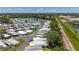 High aerial view highlighting a peaceful mobile home community with a railroad track and pond bordering its lush surroundings at 9790 66Th N St # 353, Pinellas Park, FL 33782