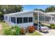 Well-maintained home featuring a carport, screened-in porch, and colorful landscaping at 9790 66Th N St # 353, Pinellas Park, FL 33782