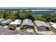 Inviting street view showcasing well-kept mobile homes with carports, beautiful landscaping, and a commercial building backdrop at 9790 66Th N St # 353, Pinellas Park, FL 33782