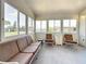 Enclosed sunroom with a sofa and chairs, providing a bright and comfortable relaxation space at 9790 66Th N St # 353, Pinellas Park, FL 33782