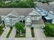 Aerial view of townhome with gray roof, green siding, manicured landscaping, and two-car garages at 10132 Post Harvest Dr, Riverview, FL 33578