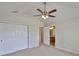 This bedroom features neutral walls, carpet flooring, a ceiling fan, double closet and attached bathroom at 10132 Post Harvest Dr, Riverview, FL 33578