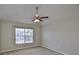 This bedroom features neutral walls, carpet flooring, a ceiling fan, and a window at 10132 Post Harvest Dr, Riverview, FL 33578
