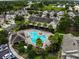 Aerial view of the community pool with lounge chairs, lush landscaping, and nearby parking at 10132 Post Harvest Dr, Riverview, FL 33578